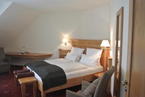 a bedroom with a bed and a desk and a chair at Hotel Jägerhof in Weibersbrunn