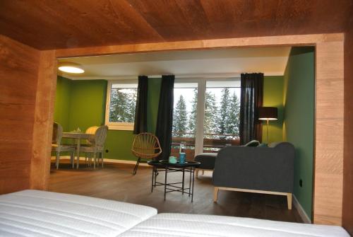 a bedroom with green walls and a couch and a table at Haus Wiesberger Apartment TOP25 Südseite in Königsleiten