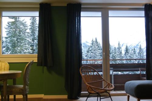 a room with two chairs and a window with trees at Haus Wiesberger Apartment TOP25 Südseite in Königsleiten