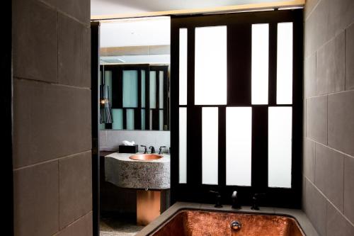 a bathroom with a tub and a sink and a mirror at Dali Sky Valley Heritage Boutique Hotel in Dali
