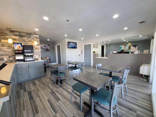 a restaurant with tables and chairs in a room at SureStay Hotel by Best Western Chowchilla Yosemite in Chowchilla