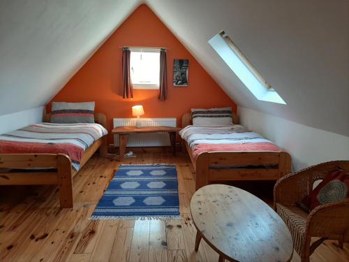 a attic room with two beds and a window at Driftwood Country Apartment in Skibbereen