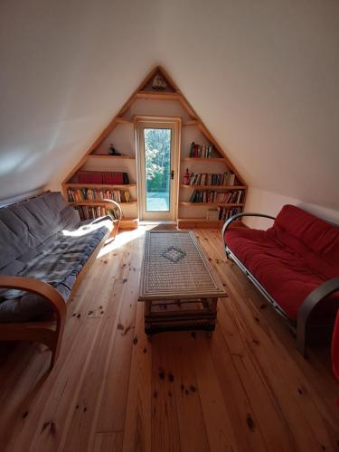 a attic room with a couch and a window at Driftwood Country Apartment in Skibbereen
