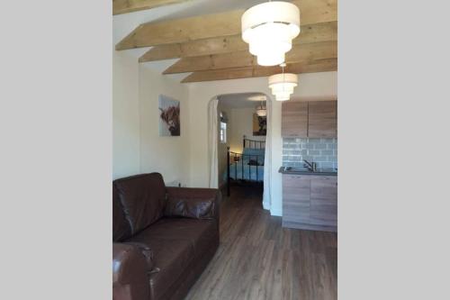 a living room with a brown couch and a kitchen at Garden rest in Seething