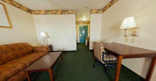 a hotel room with a couch and a desk at Country Inn & Suites by Radisson, Elkhart North, IN in Elkhart