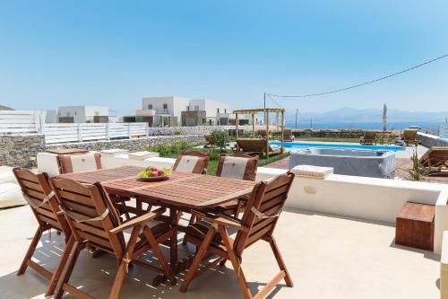 a wooden table and chairs on the roof of a house at Punda Villas Paros in Kampos Paros
