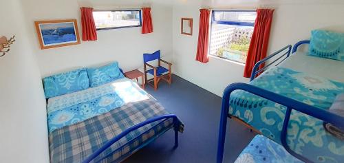 a bedroom with two bunk beds and a table at Tongariro River Retreat in Turangi