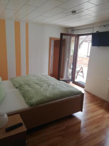 a bedroom with a bed and a large window at Bed and Breakfast - Rheingauer Hof in Oestrich-Winkel