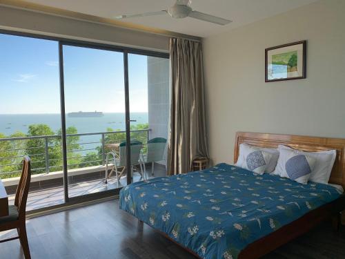 une chambre avec un lit et une vue sur l'océan dans l'établissement Bella Vista Vung Tau, à Vung Tau