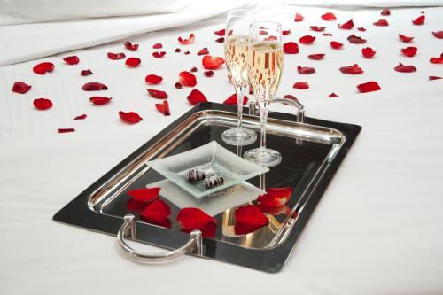 a tray with red roses and a champagne glass at Hotel Casino Magic in Neuquén