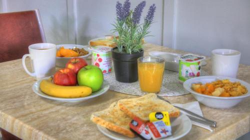 a table topped with plates of food and fruit at Glen Innes Motel in Glen Innes