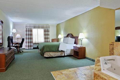 Habitación de hotel con cama y baño en Country Inn & Suites by Radisson, Charlotte University Place, NC, en Charlotte