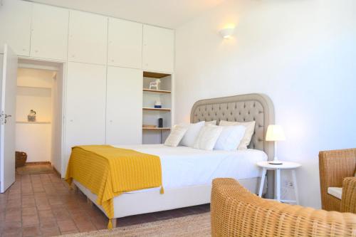 a bedroom with a bed with a yellow blanket on it at Quinta Luz do Sol in Moncarapacho