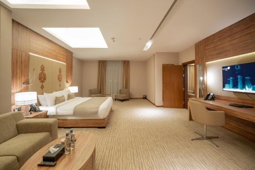 a large hotel room with a bed and a tv at V Boutique Hotel in Jeddah