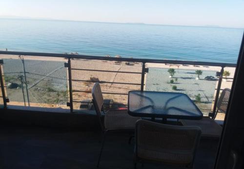 a bird sitting on the railing of a balcony overlooking the ocean at Wave n' Sea Apartments in Himare