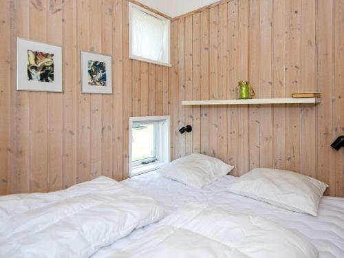 埃伯爾措夫特的住宿－Plush Holiday Home in Ebeltoft with Terrace，一张白色大床,位于带木墙的房间