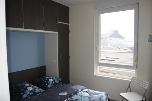 Habitación pequeña con cama y ventana en Résidence les Charmettes, en Mers-les-Bains