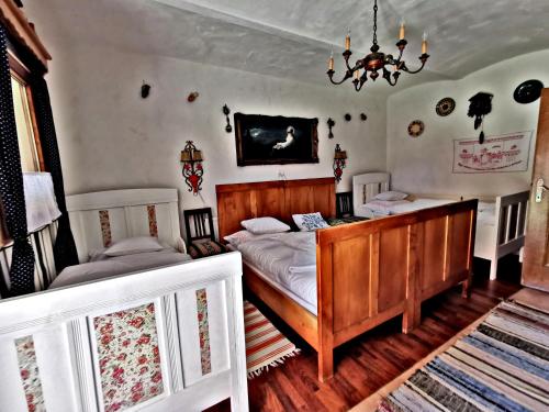 a bedroom with two beds and a chandelier at Bakonyi Kis-Lak in Bakonykoppány