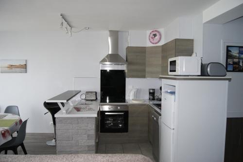 une cuisine avec une cuisinière et un réfrigérateur dans l'établissement Résidence les Charmettes, à Mers-les-Bains