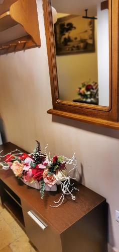a pile of flowers on a table in front of a mirror at Casa Crown in Braşov