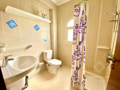 uma casa de banho com um WC branco e um lavatório. em Cozy Family 3 BR apartment by the sea em Marsa Alam