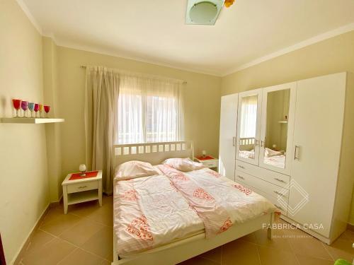 a bedroom with a bed and a large window at Cozy Family 3 BR apartment by the sea in Marsa Alam City
