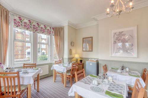 a dining room with two tables and chairs at Ellinbrook Guest House in Hunstanton