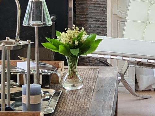 un vaso di fiori su un tavolo accanto a un letto di So Touquet a Le Touquet-Paris-Plage