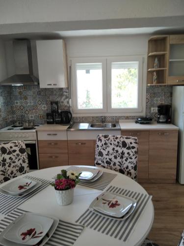 a kitchen with a table with chairs and a tableablish at LOUKIA'S HOUSE in Skala Kallirakhis