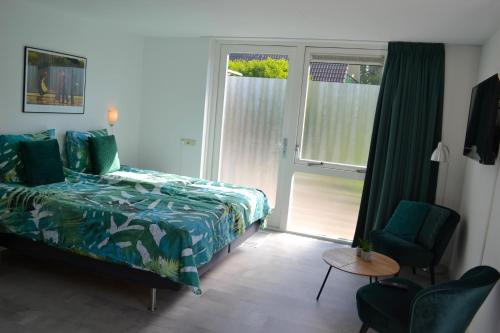 a bedroom with a bed and a window and a chair at Studio 38 in Zandvoort