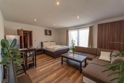 een woonkamer met een bank en een bed bij Hotel Kolonie in Frýdlant nad Ostravicí