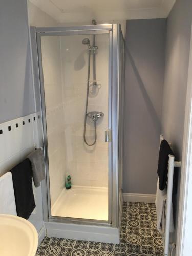 a shower with a glass door in a bathroom at The Barn Bed and Breakfast in Liverpool