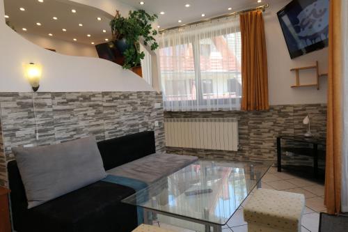 a living room with a couch and a glass table at Apartamenty u Łukasza in Zakopane