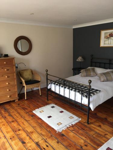 a bedroom with a bed and a dresser and a mirror at The Barn Bed and Breakfast in Liverpool