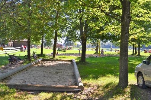 a sandbox in a park with trees and a car at Niederauer Hof in Neubeuern