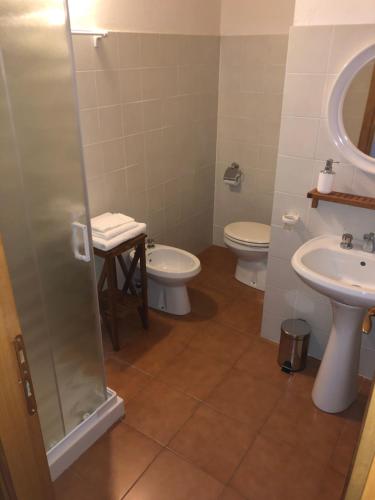 een badkamer met 2 toiletten, een wastafel en een douche bij La vecchia canonica in Fivizzano