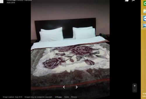 Un dormitorio con una cama con flores. en Centurion Hotel, en Naran
