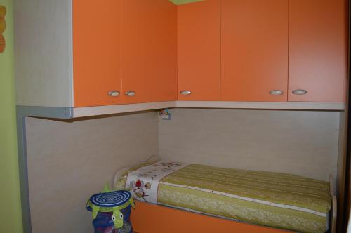 a small room with orange cabinets and a bed at La Casetta di Lettopalena in Lettopalena