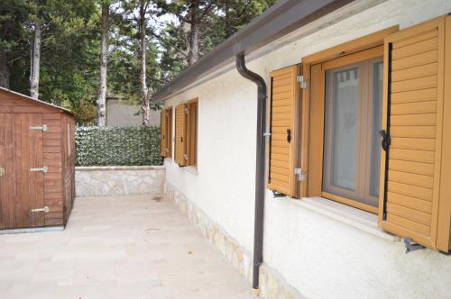 a house with wooden doors and a patio at La Casetta di Lettopalena in Lettopalena