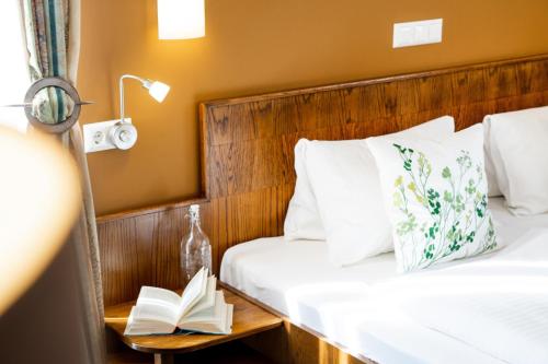 a bedroom with two beds and a book on a night stand at Pension Waldfriede in Bad Tatzmannsdorf