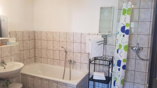 ein Badezimmer mit einer Badewanne und einem Waschbecken in der Unterkunft Hotels Green Lemon Garni – Haus Krähenhütte in Bad Sulza