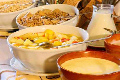 a table with several bowls of food and milk at Pension Waldfriede in Bad Tatzmannsdorf