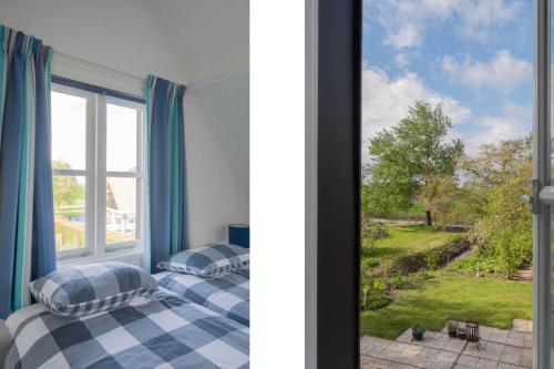 two beds in a room with a window at Prachtig gelegen vrijstaand landhuis in Hansweert