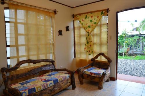 two beds in a room with a window and a door at Apartamentos Herrera in Puerto Jiménez