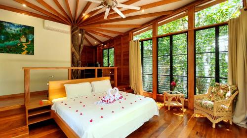 a bedroom with a bed and large windows at Vanilla Hills Lodge in San Ignacio