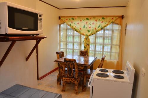 a small kitchen with a table and a microwave at Apartamentos Herrera in Puerto Jiménez
