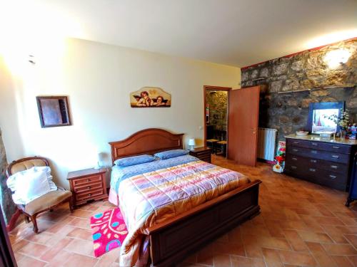 ein Schlafzimmer mit einem Bett und einer Steinmauer in der Unterkunft Antico Fienile in Celleno