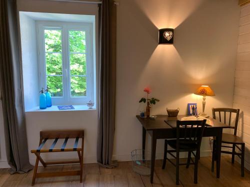 une salle à manger avec une table et des chaises et une fenêtre dans l'établissement La Colonie - Maison d'Hôtes, à Collonges