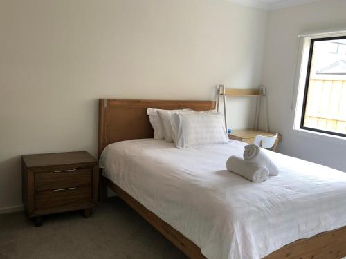 a bedroom with a white bed and a window at Apple House Upper Point Cook in Point Cook