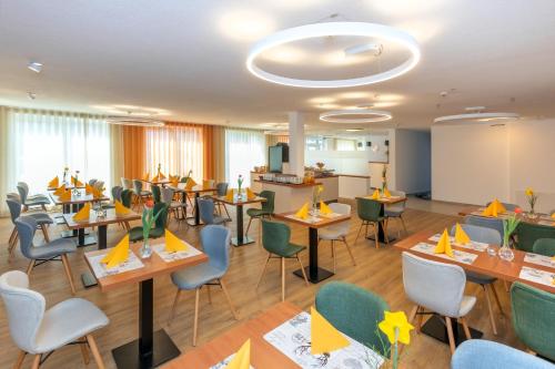a restaurant with tables and chairs with yellow napkins at Hotel La Mirabelle close to Europa Park in Rheinhausen